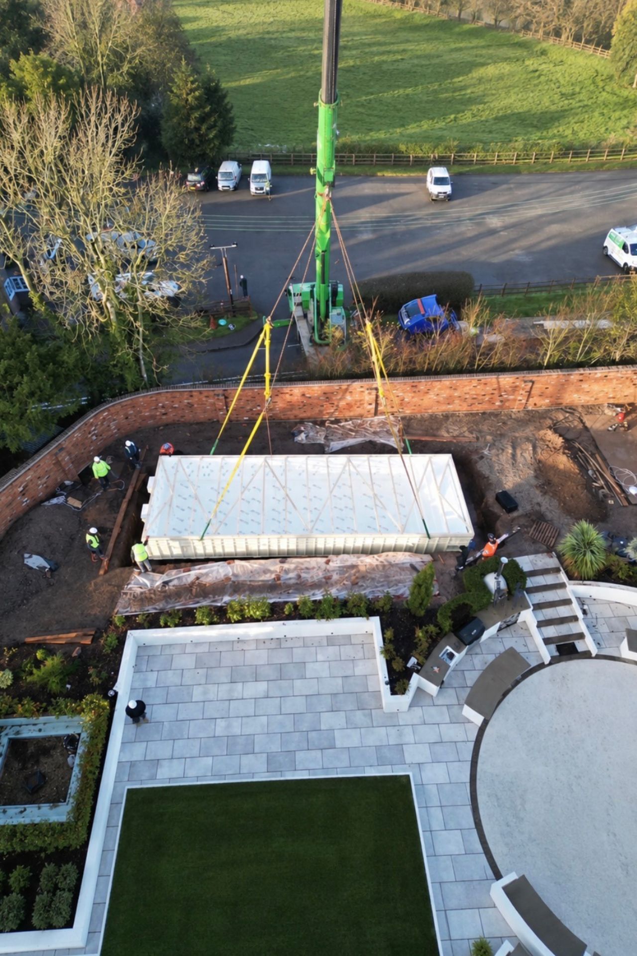 Aerial view of the Flexline pool being craned into the garden